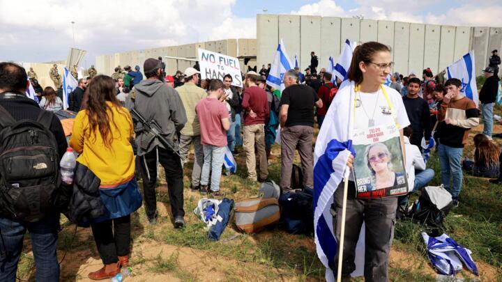On the Israeli side of the border crossing with the Gaza Strip, a protester carries a portrait of a hostage during a demonstration aimed at blocking aid trucks from entering the Palestinian enclave on