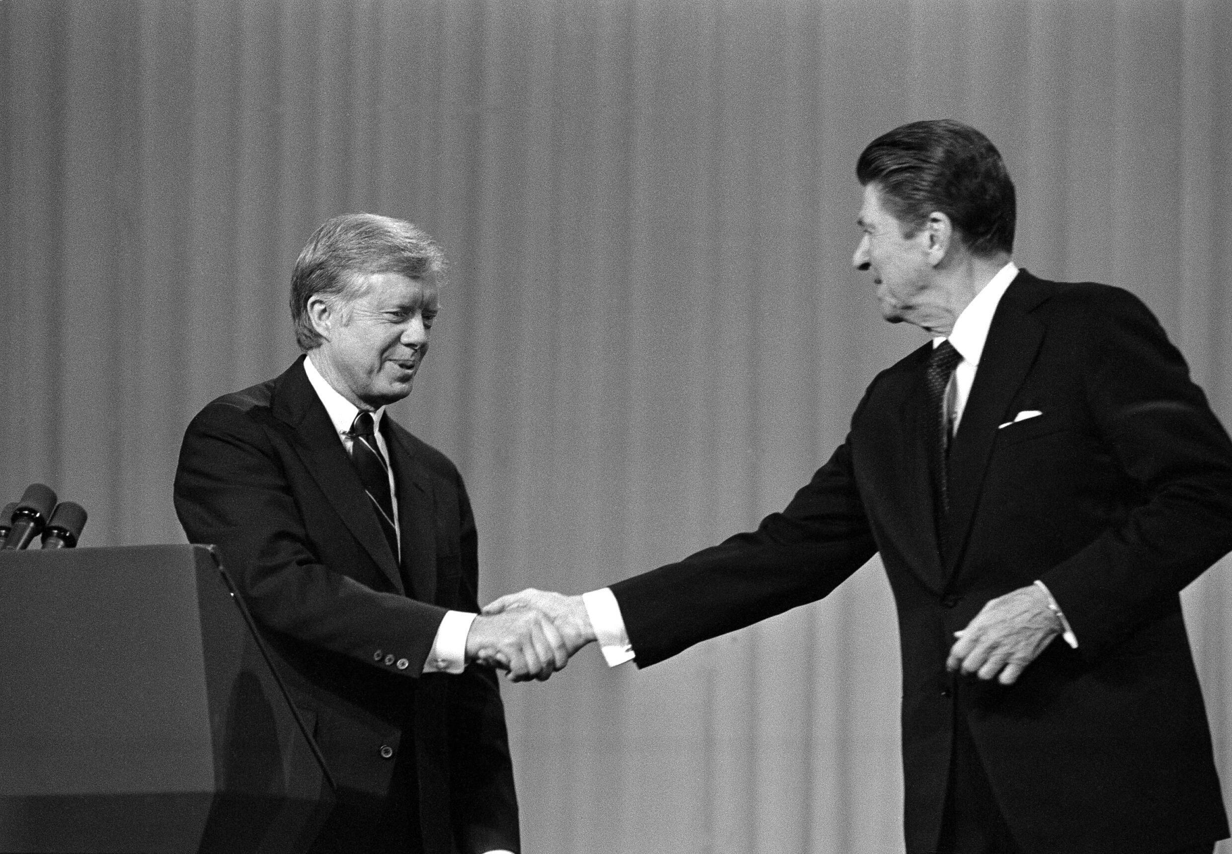 Le président américain Jimmy Carter salue son adversaire, le candidat républicain Ronald Reagan, lors d'un débat organisé à Cleveland, le 28 octobre 1980.