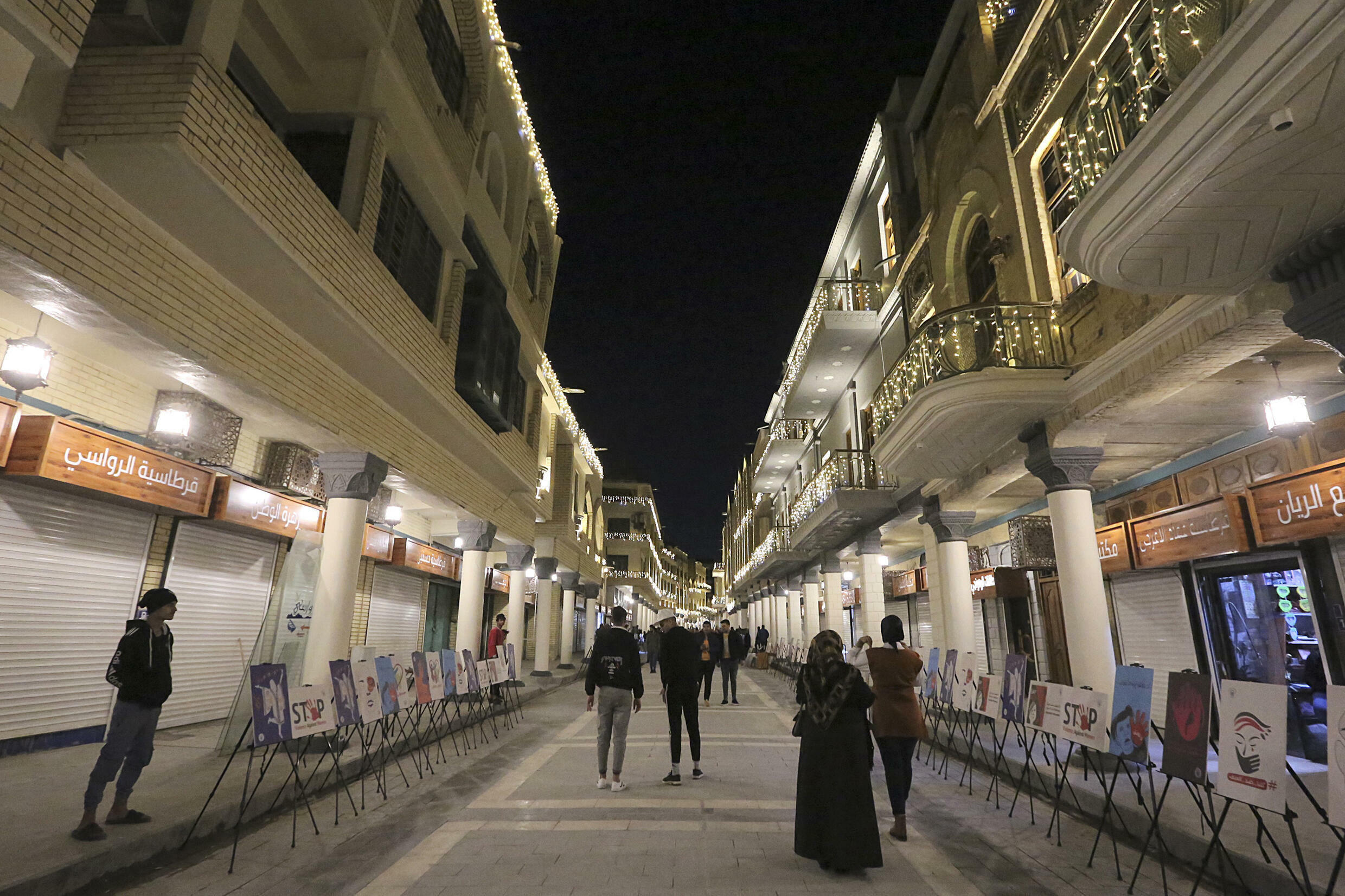 People walk along the renovated Al-Mutanabbi Street, where in March 2007 a suicide car bomb killed 30 people and wounded 60 others