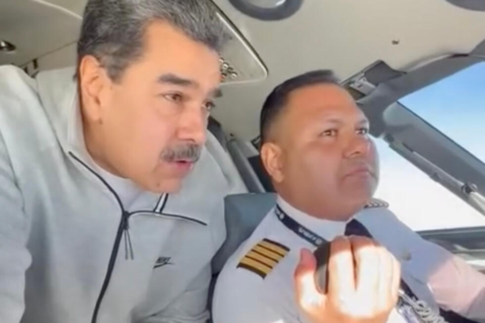 Venezuelan President Nicolás Maduro stands behind pilot Gen. Bitner Villegas in the cockpit of an airplane.