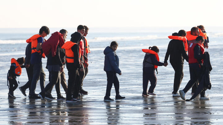 Migrants walk away from the beach after a failed attempt to cross the English Channel to reach Britain from France, September 27, 2025. 