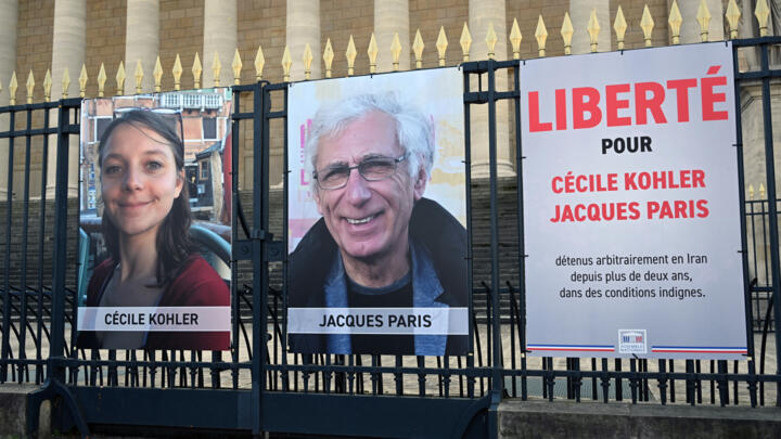 This photograph shows the newly displayed portraits of French national Cecile Kohler (L) currently imprisoned in Iran with her partner French national Jacques Paris.