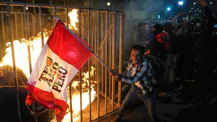 A demonstrator waves a Peruvian flag in front of Congress during a protest against new President Jose Jeri in Lima, October 15, 2025.