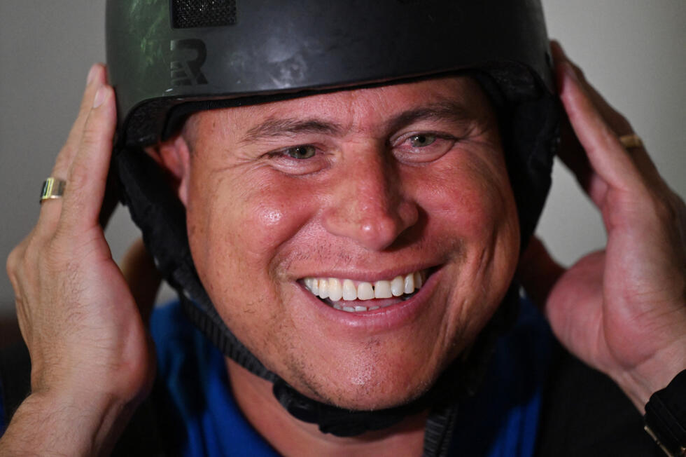 Salvadoran journalist Mario Guevara, 48, deported from the United States, smiles as he tries on his riot helmet at a relative's house in Apopa, El Salvador, on October 6, 2025