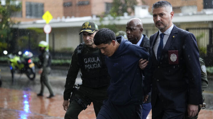 US Drug Enforcement agents and Colombian police escort an alleged member of the Tren de Aragua transnational gang into a police station in Bogota, on February 6, 2025.