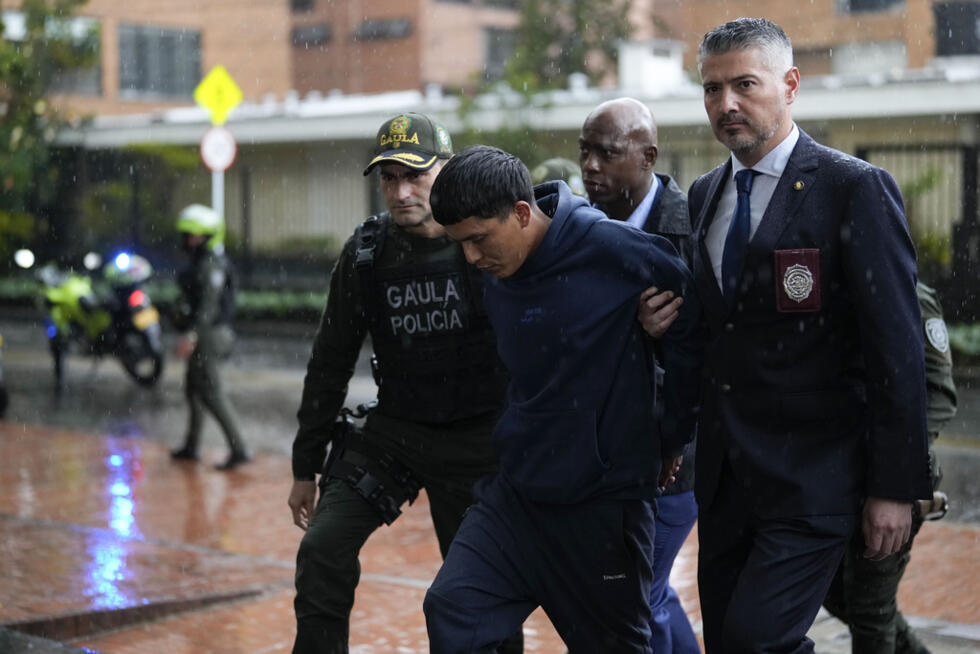 US Drug Enforcement agents and Colombian police escort an alleged member of the Tren de Aragua transnational gang into a police station in Bogota on February 6, 2025.
