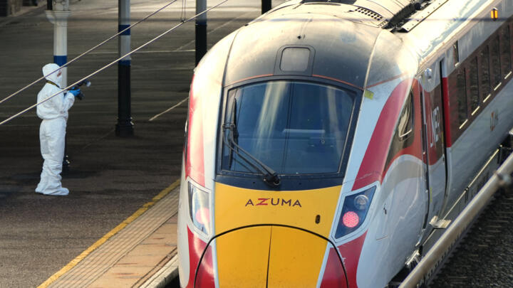 A forensic investigator takes pictures of the train after a mass stabbing on a London-bound train in Huntingdon, England, Sunday, November 2, 2025.