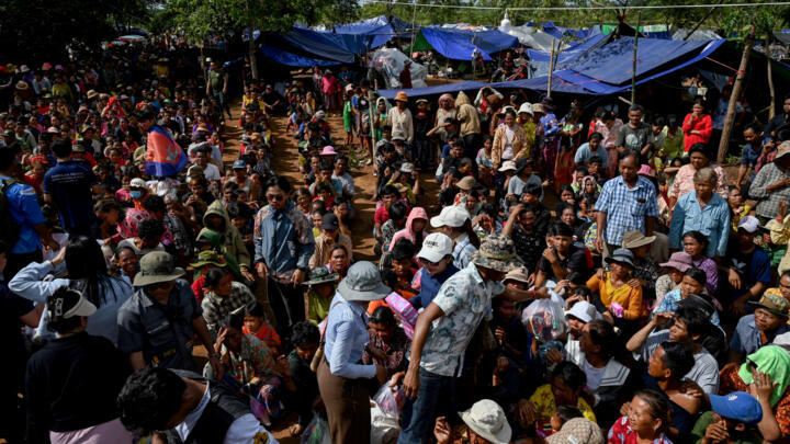 People who fled their homes near the border between Cambodia and Thailand gather at a food distribution site on the grounds of a pagoda in Oddar Meanchey province, Cambodia