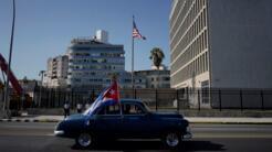 Archivo-Un auto de época pasa junto a la Embajada de Estados Unidos portando una bandera cubana en la Habana, Cuba